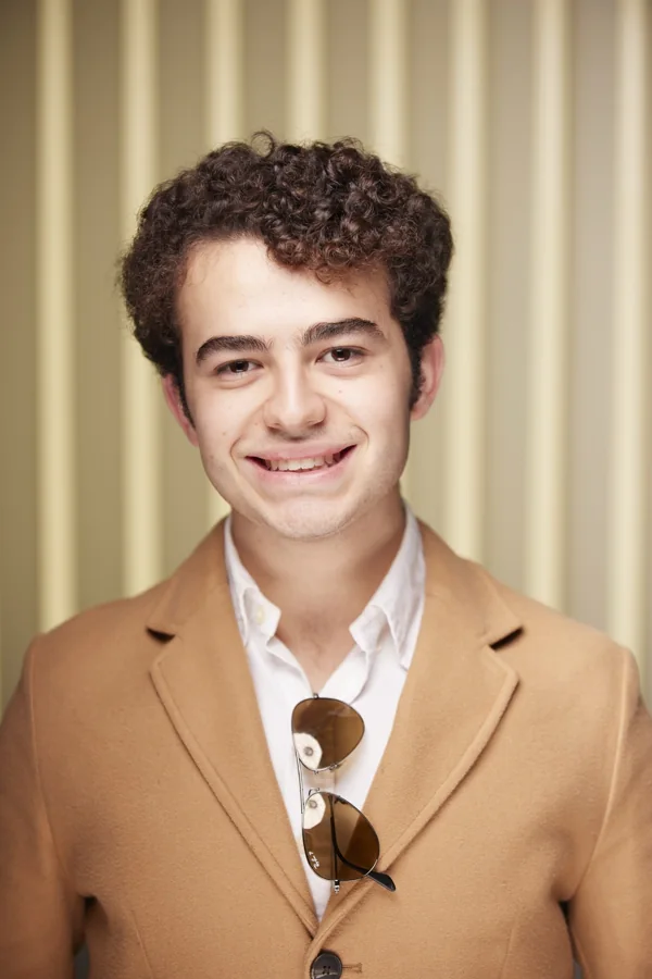 Daniel Helo Puccini smiling, in a camel coat and white shirt